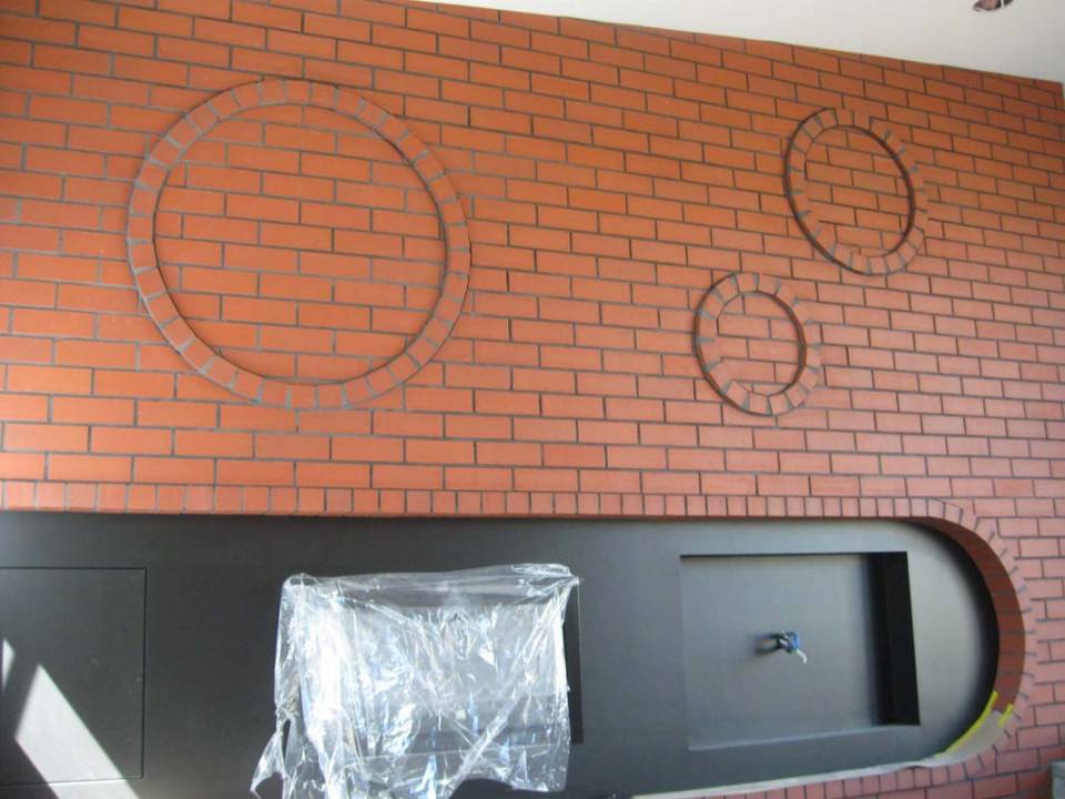 Red brick wall with protruding circular features